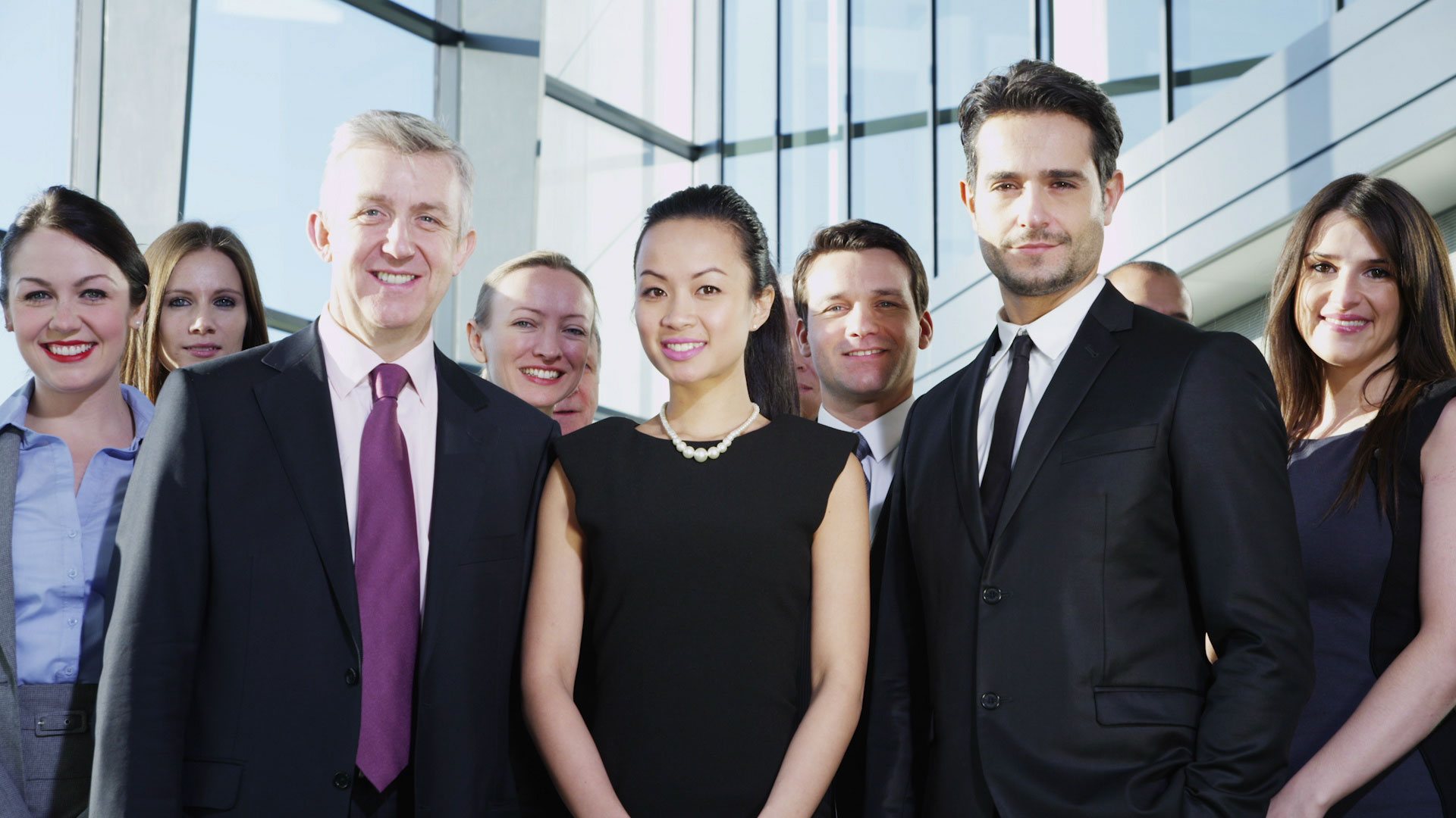 Team of proud employees walking towards camera